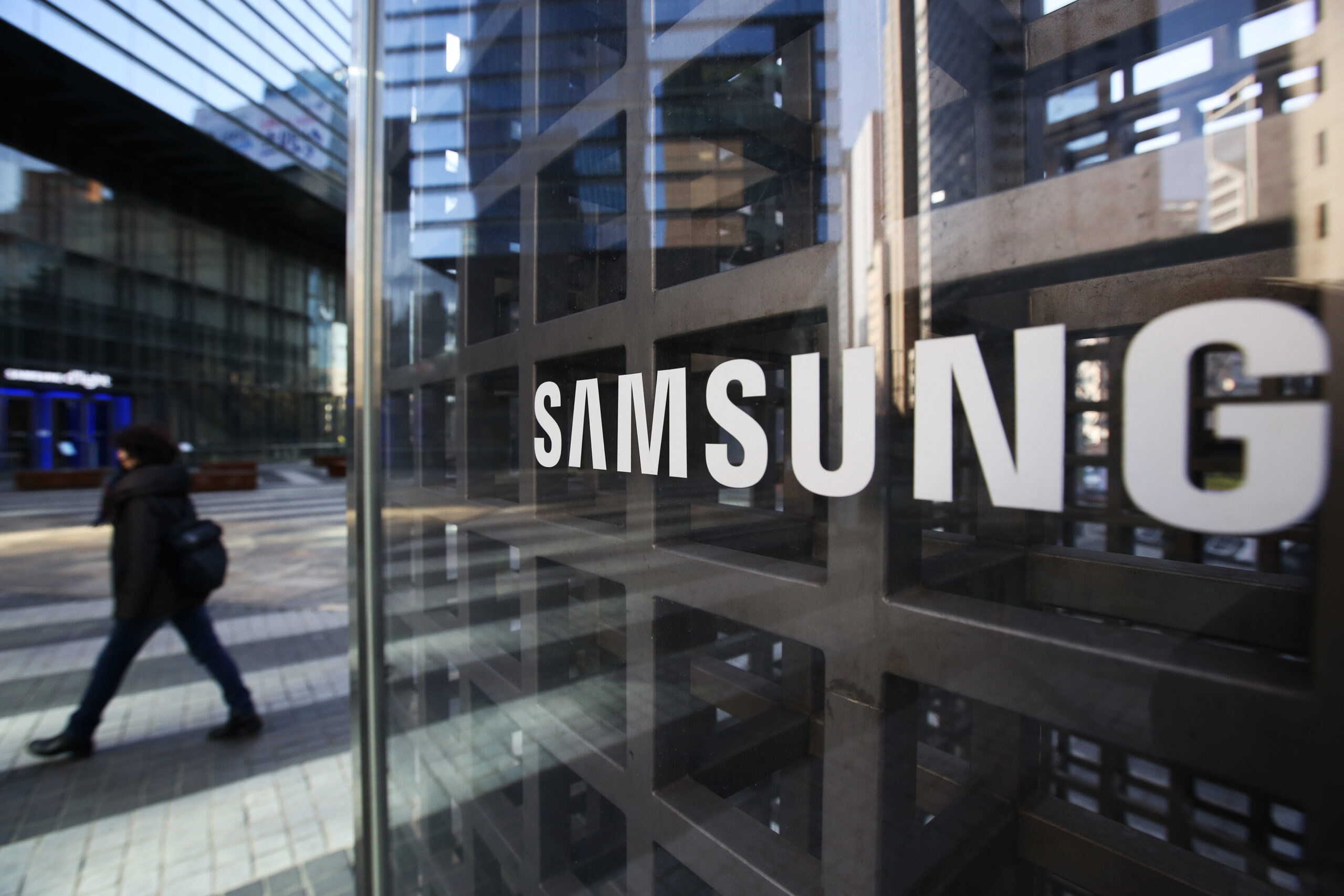 A woman walks past Samsung Electronics Co. signage outside the company's Seocho office building in Seoul, South Korea, on Friday, Feb. 17, 2017. Samsung Group's Jay Y. Lee was formally arrested on allegations of bribery, perjury and embezzlement, an extraordinary step that jeopardizes the executive's ascent to the top role at the world's biggest smartphone maker. Photographer: SeongJoon Cho/Bloomberg via Getty Images