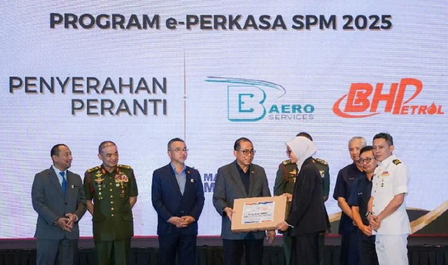 Dato' Seri Haji Mohamed Khaled bin Nordin menyerahkan peranti digital kepada pelajar SPM